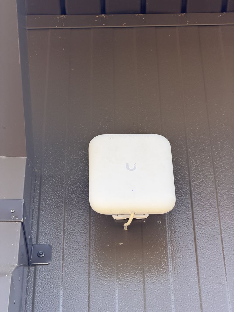 UniFi U7 Pro Outdoor access point mounted under the building eave