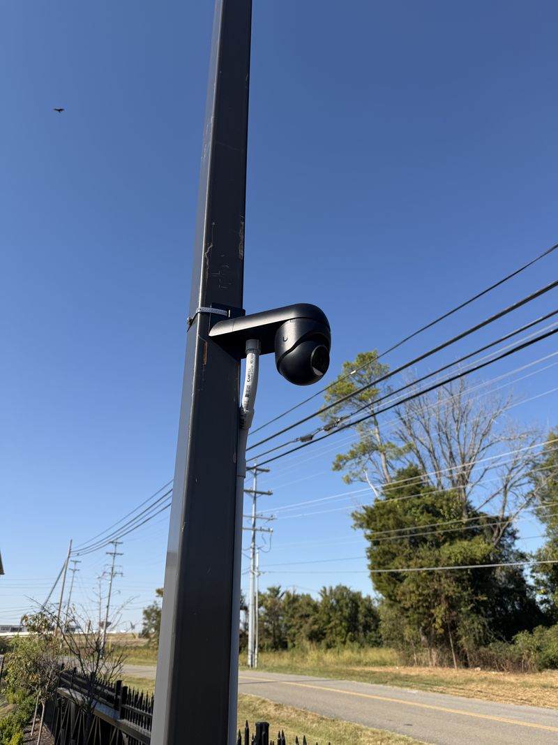 UniFi camera on an arm bracket on a light pole beside the parking lot